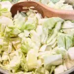 picture of raw chopped cabbage in pan with wooden spoon