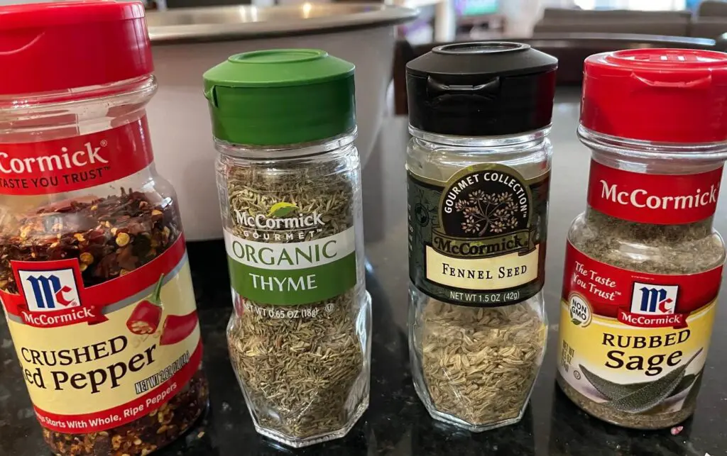 Picture of spice bottles used in low sodium sausage recipe: crushed red pepper, thyme, fennel and sage.