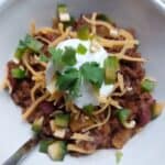 image of low sodium chili topped with sour cream, cheese, peppers and cilantro